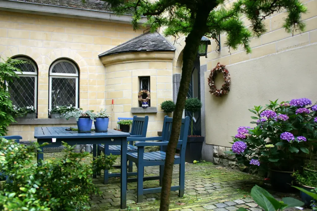 Schattige Terrasse vor dem Haus, mit Moos bewachsen.