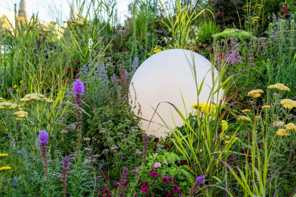 Gartenkugel aus Kunststoff im Blumenbeet.
