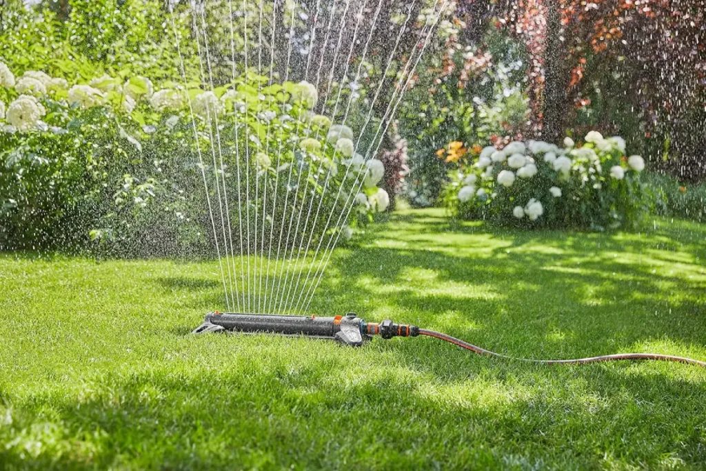 Viereck-Regner steht auf dem Rasen im Garten.