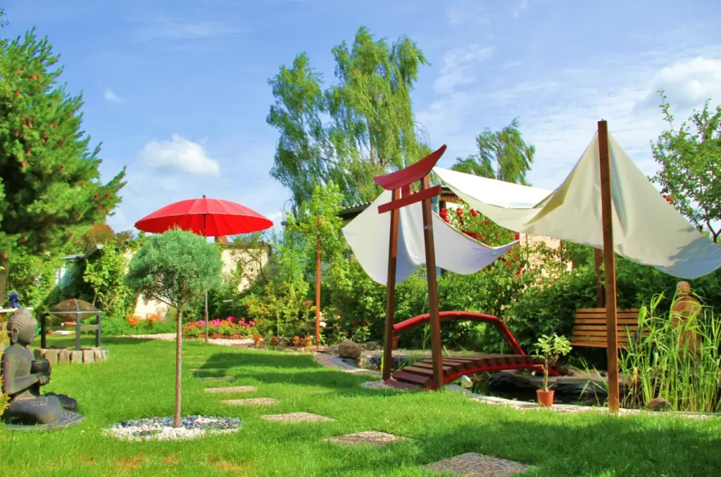 Sonnensegel sind als Sonnenschutz über einen Teich im Garten gespannt.