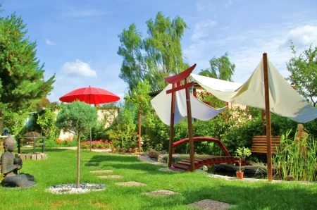 Sonnensegel sind als Sonnenschutz über einen Teich im Garten gespannt.