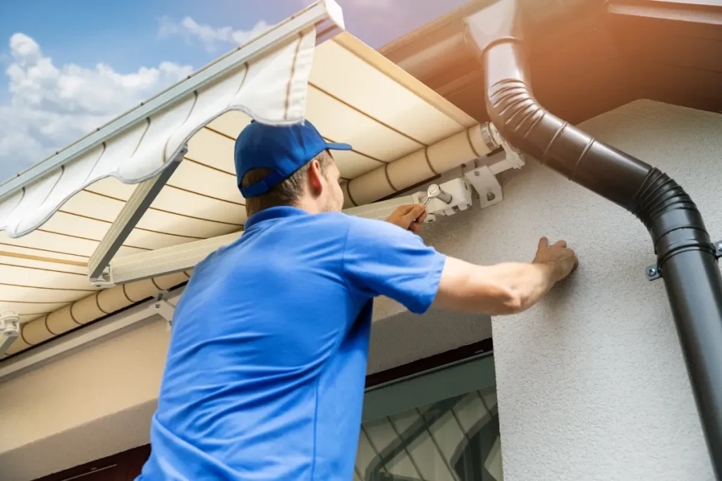 Handwerker richtet Gelenkarm-Markise aus.