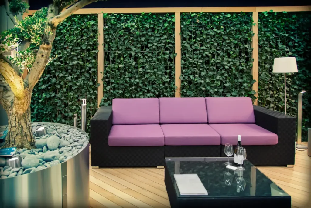 Mit Efeu bewachsene Wand aus Gitterstabmatten als Sichtschutz.