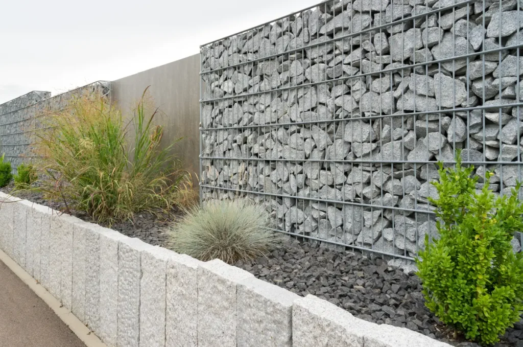 Ein Zaun aus Gabionen dient als Sichtschutz.