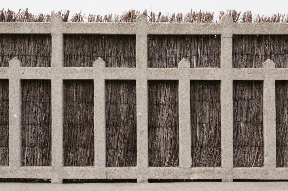 Betonmauer mit montierter Sichtschutzmatte.