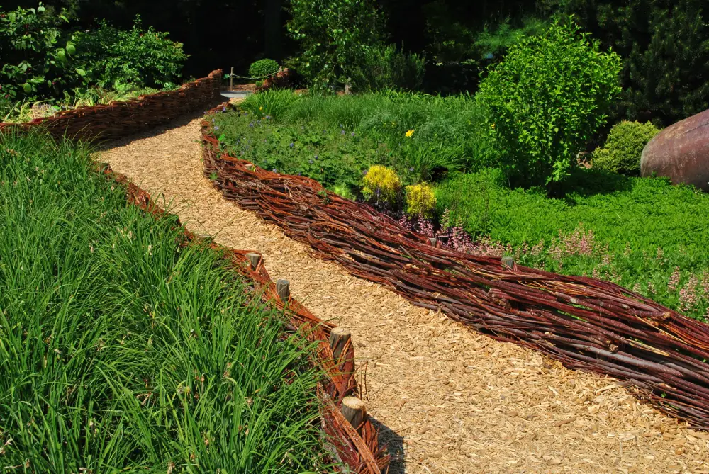 Flechtzaun aus Weidenruten im Garten.