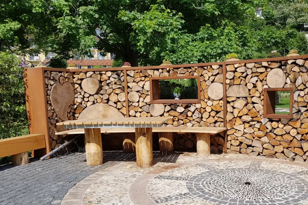 Brennholz wurde, neben einer Terrasse mit Tisch und Bank, zu einer Wand gestapelt.