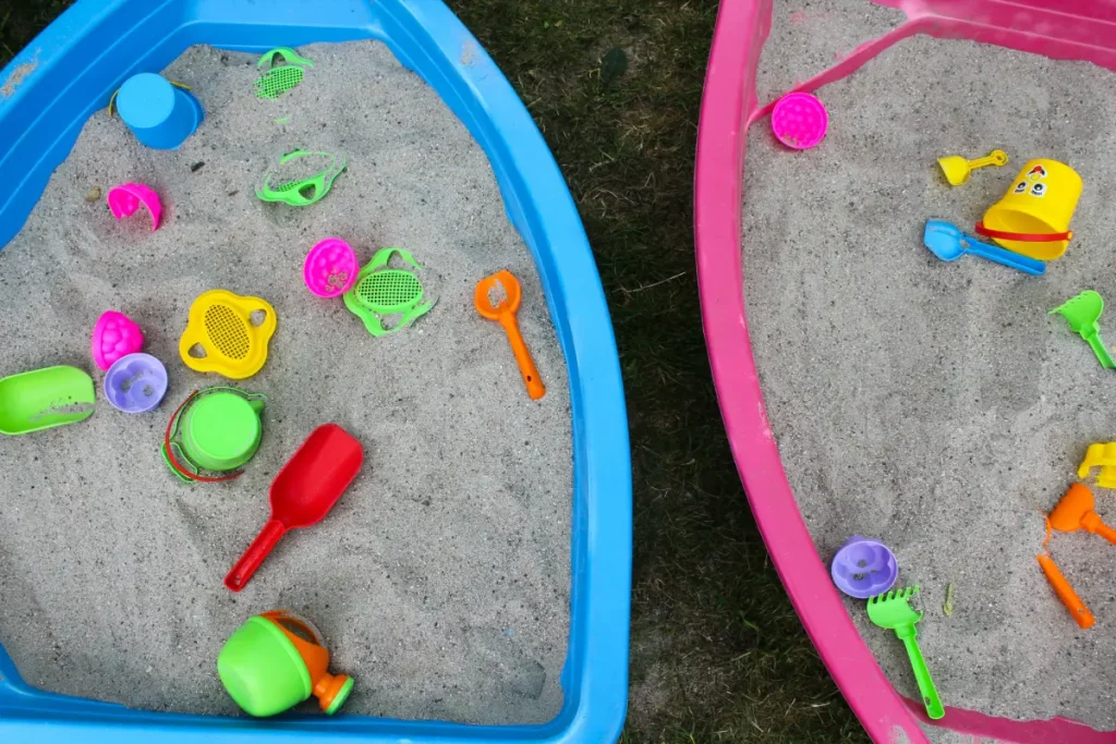 Sandkasten aus zwei nebeneinander gestellten Plastik-Spielbooten.