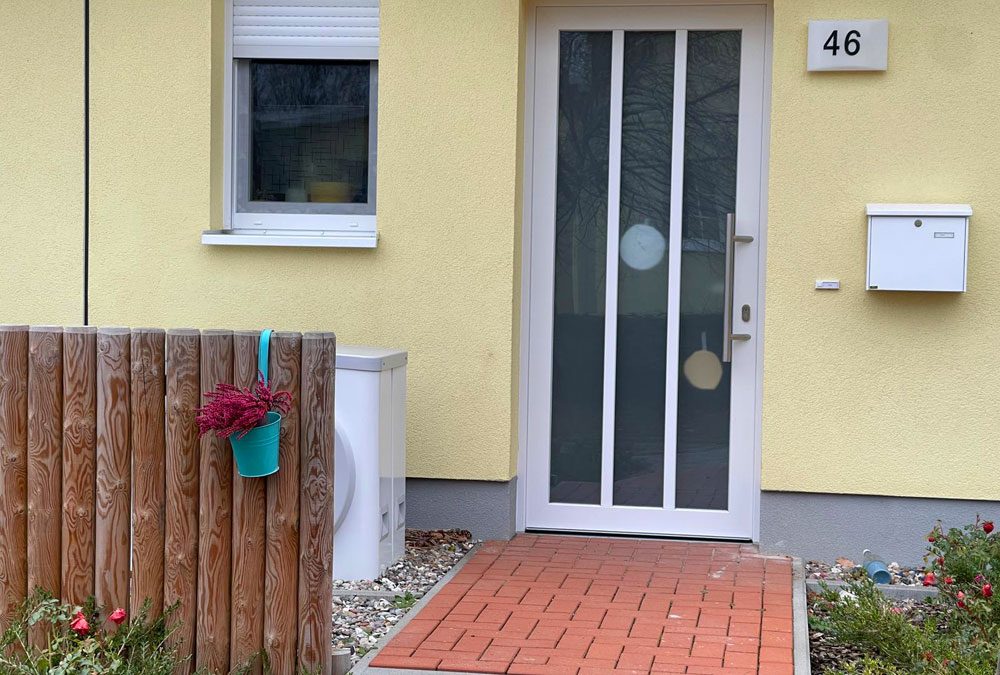 Holzzaun vor einer Wärmepumpe im Hauseingangsbereich Wärmepumpe Verkleidung