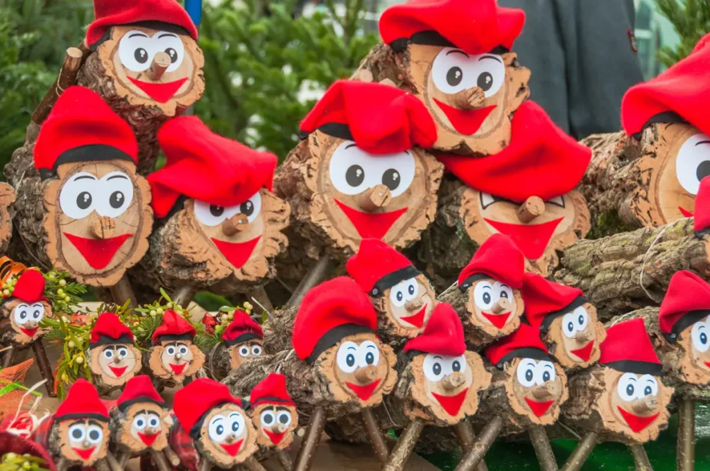 Baumscheibe mit Gesicht und Zipfelmütze zur weihnachtlichen Dekoration.