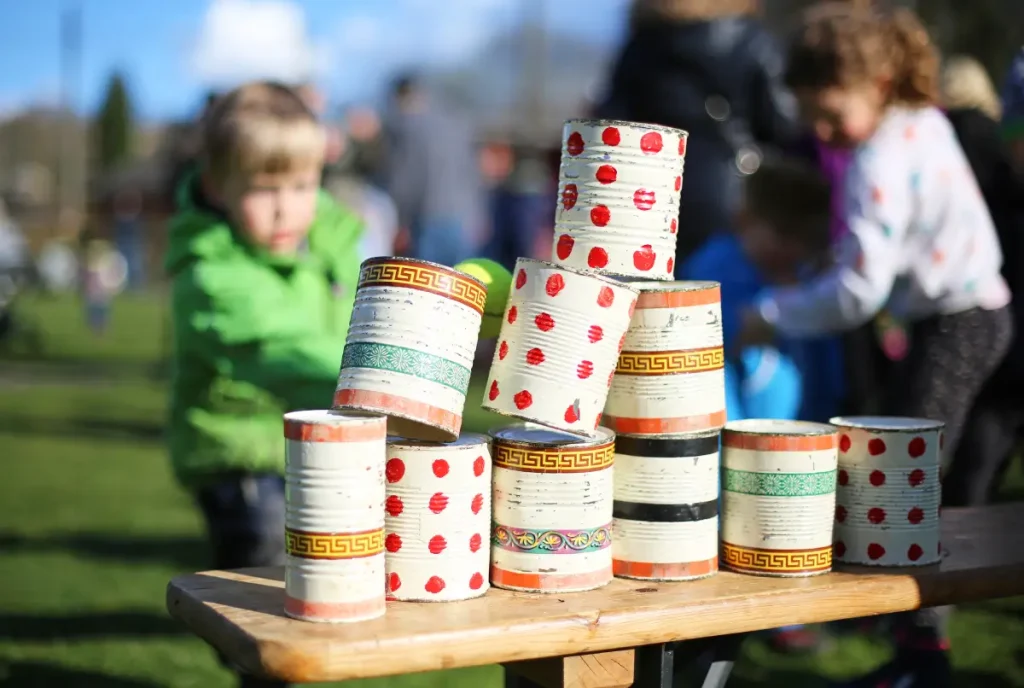 Kind beim Dosenwerfen im Garten Gartenspielzeug: 8 einfache DIY-Ideen für Ihre Kinder