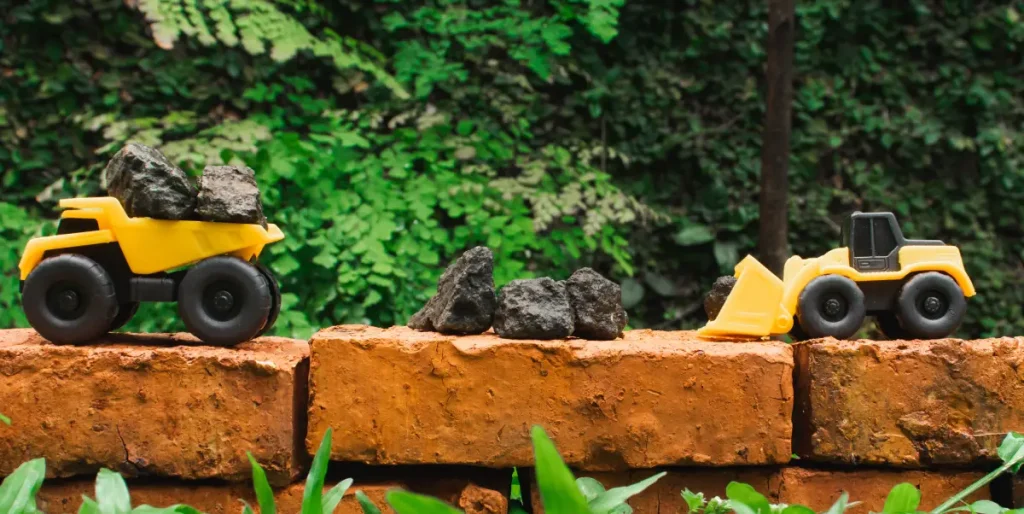 Spielzeugfahrzeuge auf einer Mauer im Garten Gartenspielzeug: 8 einfache DIY-Ideen für Ihre Kinder