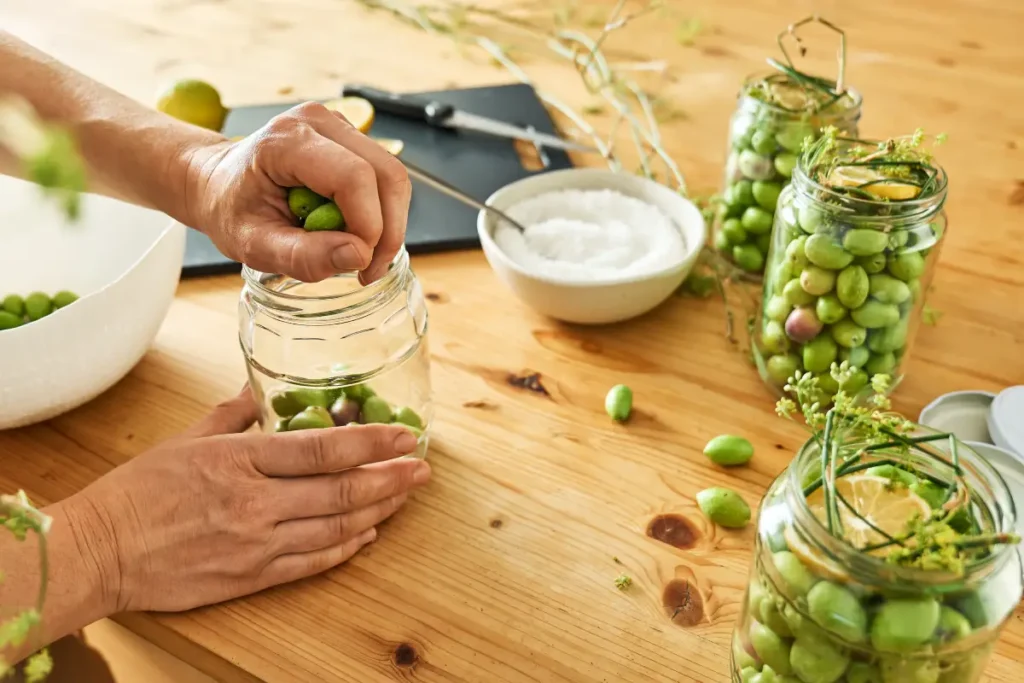 Oliven werden in Gläser gefüllt Oliven einlegen - 3 köstliche Rezepte vorgestellt