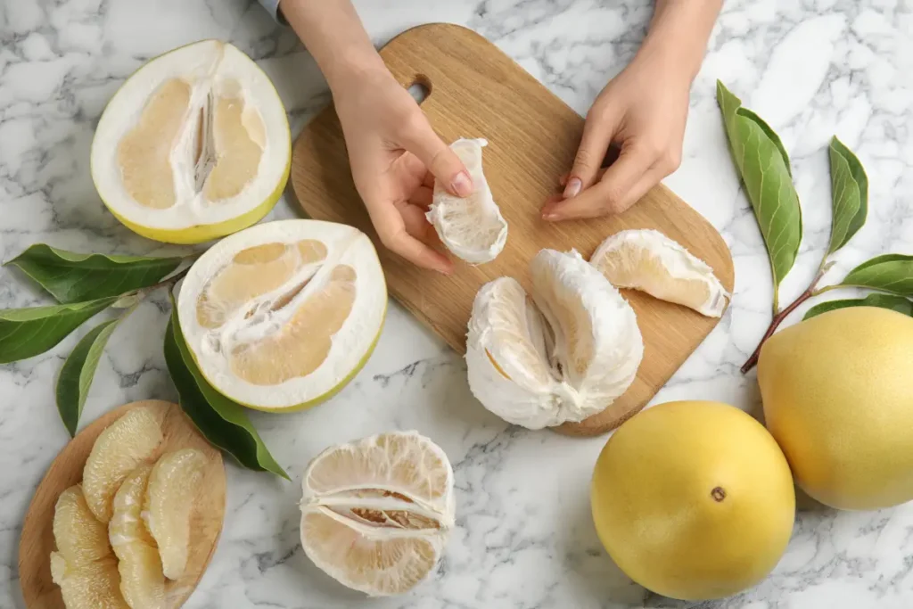 Hände halten Stück einer Pomelo Pomelo pflanzen, pflegen und vermehren